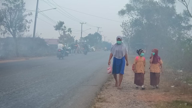 Warga di Kecamatan Bati-bati, Kabupaten Tanah Laut, pakai masker karena kabut asap pekat. Foto: ACT Kalsel