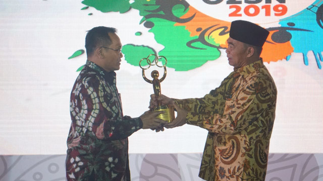 com-Mendikbud Muhadjir Effendy saat menyerahkan piala O2SN 2019. Foto: Dok. Kemendikbud