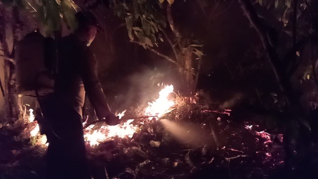 Personel Polres Tojo Una - Una tengah membantu masyarakat di Kecamatan Tojo, Kabupaten Tojo Una-Una, Sulawesi Tengah memadamkan api, Senin malam (9/9). Foto: Dok.Polres Tojo Una - Una