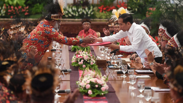 Presiden Joko Widodo (kanan) menerima map berisi saran dari perwakilan tokoh Papua Abisai Rollo (kiri) dalam pertemuan di Istana Negara, Jakarta, Selasa (10/9). Foto: ANTARA FOTO/Akbar Nugroho Gumay