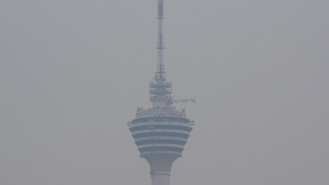 Menara Kuala Lumpur terlihat diselimuti kabut asap di Malaysia. Foto: AFP/MOHD RASFAN