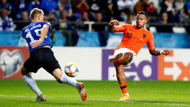 Penyerang Belanda, Memphis Depay (kanan), menendang bola melewati bek Estonia, Ragnar Klavan. Foto: Reuters/Ints Kalnins