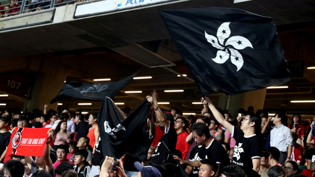 Demonstran mengibarkan bendera hitam Hong Kong untuk mendukung demonstran anti-pemerintah di pertandingan kualifikasi Piala Dunia sepak bola antara Hong Kong dan Iran, di Stadion Hong Kong, Cina, Selasa (10/9) Foto: REUTERS/Athit Perawongmetha