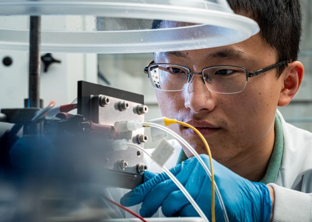 Haotian Wang, anggota tim peneliti, memeriksa alat  pengubah karbon dioksida jadi bahan bakar buatannya. Foto: Jeff Fitlow via Rice University.