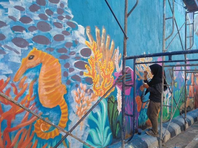 Proses pelukisan mural Underpass Unila oleh seniman yang tergabung dalam komunitas Kuas Lampung, Rabu (11/9) | Foto: Rafika Restiningtias/ Lampung Geh