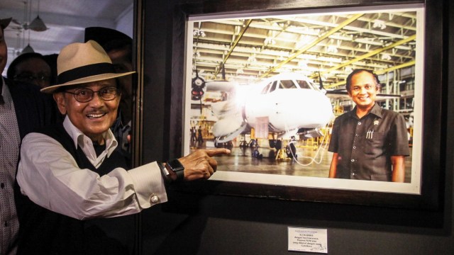 Mantan presiden BJ Habibie menunjukan foto dirinya bersama pesawat hasil karyanya N-250 'Gatotkaca' usai membuka  pameran foto 'Cinta Sang Inspirator Bangsa Kepada Negeri' di Museum Bank Mandiri, Jakarta, Minggu (24/7/2016). Foto: ANTARA FOTO/Muhammad Adimaja