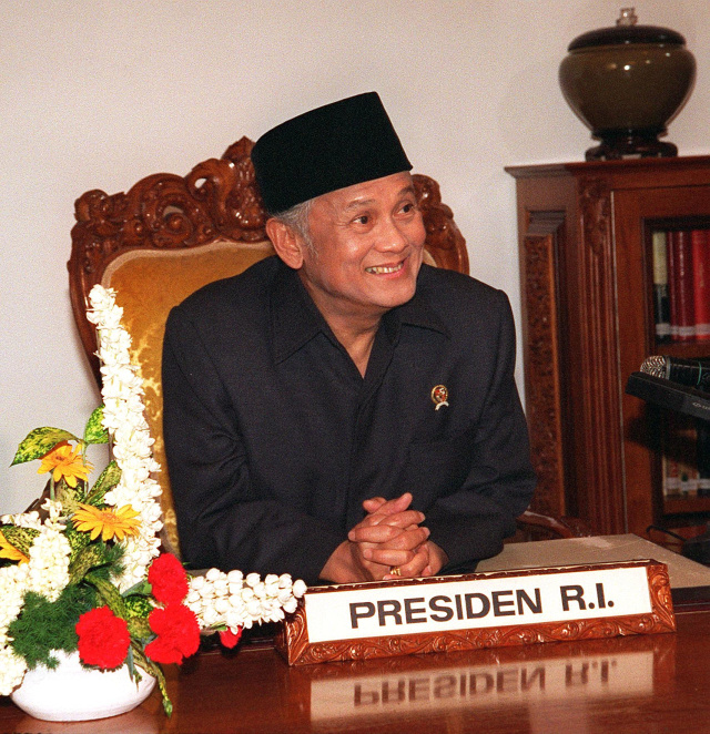 Presiden Indonesia yang baru diangkat, BJ Habibie, tersenyum ketika dia mempersiapkan pidatonya kepada negara di kantor kepresidenan di Jakarta 21 Mei. Foto: AFP/AGUS LOLONG