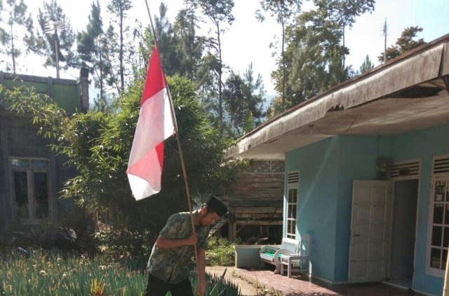 Warga Sigedong, Kecamatan Bumijawa, Kabupaten Tegal, memasang bendera setengah tiang di depan rumahnya. (Foto: Bentar)