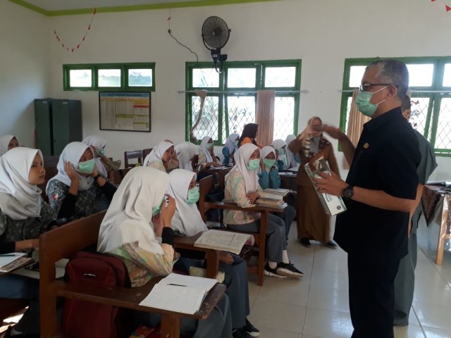 Kepala Dinas Pendidikan Sumsel, Widodo, saat membagikan masker kepada siswa sekolan. (Foto: istimewa)