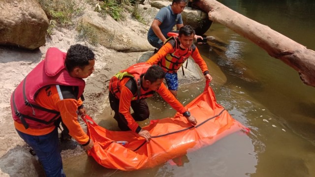 Petugas BPBD saat mengevakuasi pemancing yang sempat hilang di Sungai Aek Silau