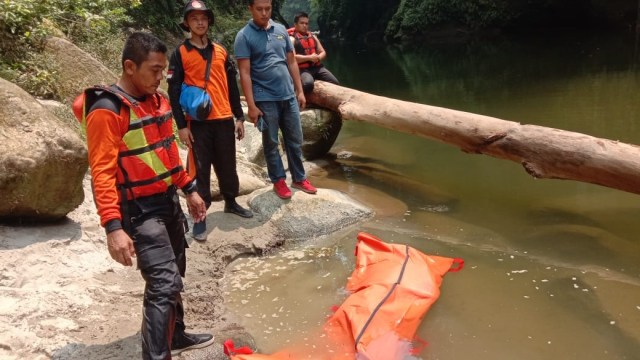 Petugas BPBD saat mengevakuasi pemancing yang sempat hilang di Sungai Aek Silau