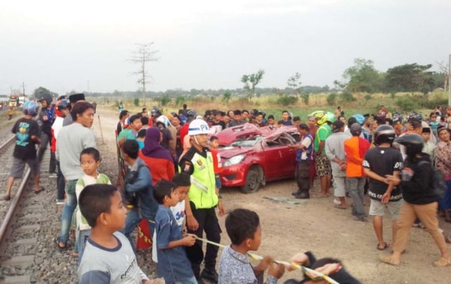 Mobil Datsun Go Panca yang tertabrak kereta api di Jombang jadi tontonan warga.