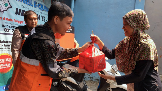 Warga kampung sedekah bagi-bagi kotak Sedekah Nasi Ngider (Senang). Foto: Darin Atiandia/kumparan