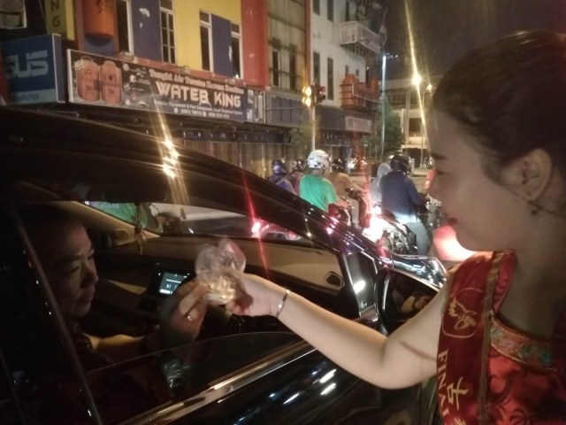 Koko dan Meimei membagikan kue bulan kepada pengguna jalan di Pontianak, Kalbar. Foto: Lydia Salsabila/Hi!Pontianak