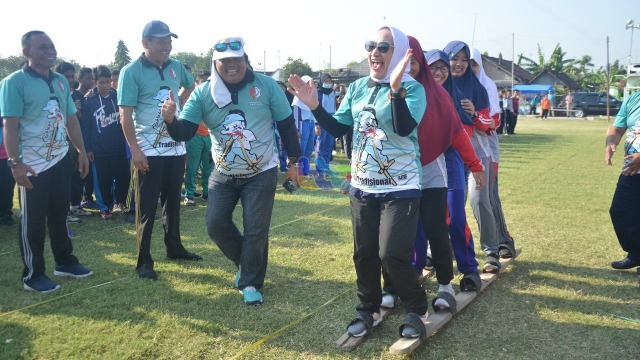 Bupati Bojonegoro, Dr Hj Anna Muawanah, saat mencoba olahraga tradisional terompah panjang, usai membuka Kejuaraan Olahraga Tradisional Tahun 2019, di Lapangan Condro Mowo Desa Talun Kecamatan Sumberrejo Bojonegoro. Sabtu (14/09/2019) 