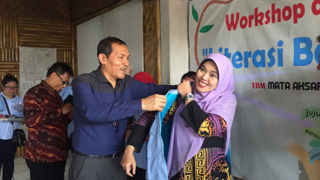 Saut Situmorang memakaikan rompi kepada peserta workshop di Taman Baca Masyarakat (TBM) Mata Aksara Jalan Kaliurang, Sleman, DI Yogyakarta, Sabtu (14/9). Foto: Arfiansyah Panji Purnandaru/kumparan