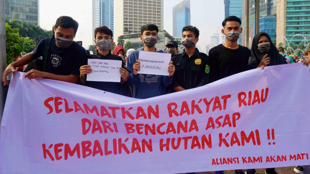 Sejumlah massa aksi solidaritas korban kabut asap Riau memakai masker di CFD Jakarta. Foto: Irfan Adi Saputra/kumparan