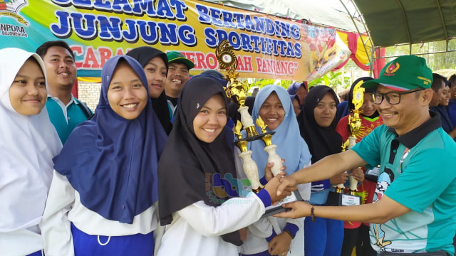 Kabid Olahraga, Dinas Kepemudaan dan Olahraga (Dinpora) Kabupaten Bojonegoro, Syaifuddin SPd, saat serahkan piala kepada juara cabang olahraga Dagongan Putri. Minggu (15/09/2019)