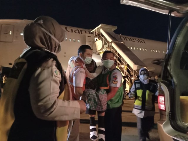 Petugas haji membantu jemaah haji kloter terakhir debarkasi Aceh usia renta setibanya di Bandar Udara Sultan Iskandar Muda, Minggu (15/9). Foto: Dok. PPIH Aceh