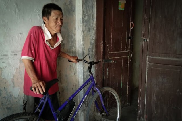 Afuk dan sepeda ontelnya yang ia gunakan untuk pergi ke Pasuruan. (Tara Wahyu)