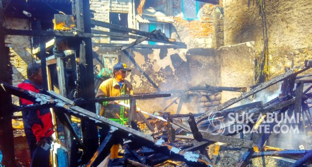 Petugas melakukan pendinginan di sebuah gudang milik warga Baros, Kota Sukabumi yang terbakar, Senin (16/9/2019). | Sumber Foto:Oksa BC.