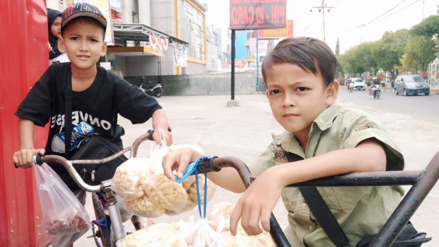 Irfan dan Agus, dua bocah penjual kerupuk, ditemui di Jalan Hasan Basri, Banjarmasin, pada Minggu (15/9). Foto: Zahidi/banjarhits.id