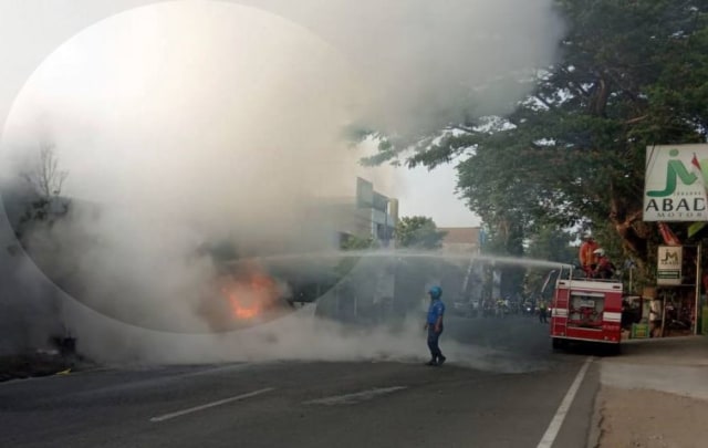 Petugas PMK memadamkan api yang membakar pikap angkut BBM di Blitar