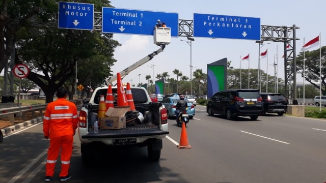 Petugas menghapus tulisan pegi-pegi dan traveloka dari rambu petunjuk arah terminal di Bandara Soekarno-Hatta. Foto: Dok. Istimewa