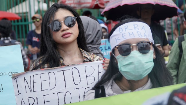 Massa aksi menunjukan poster dengan berbagai tuntutan, saat berunjuk rasa di depan Gedung DPR RI, Jalan Gatot Subroto, Jakarta, Senin (16/9/2019). Foto: Jamal Ramadhan/kumparan