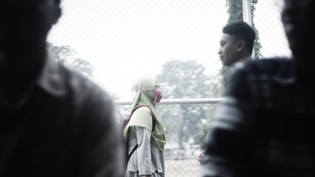 Seorang mahasiswi mengenakan masker penutup untuk mengurangi resiko polusi asap akibat pembakaran lahan, Selasa (17/9), Foto:abp/Urban Id