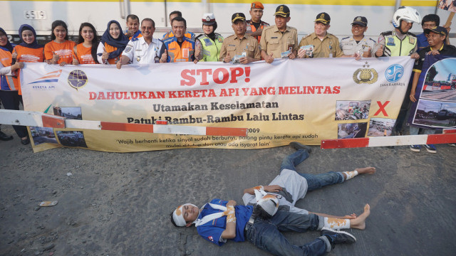 Sejumlah petugas membentangkan baliho sosialisasi keselamatan di Perlintasan sebidang Bukit Duri, Jakarta Selatan, Selasa (17/9/2019). Foto: Helmi Afandi Abdullah/kumparan