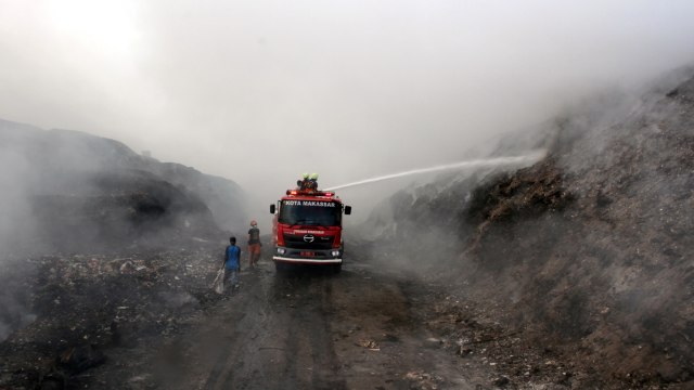 Petugas pemadam kebakaran memadamkan api di Tempat Pembuangan Akhir (TPA) Antang, Makassar, Sulawesi Selatan, Senin (16/9/2019). Foto: ANTARA FOTO/Arnas Padda