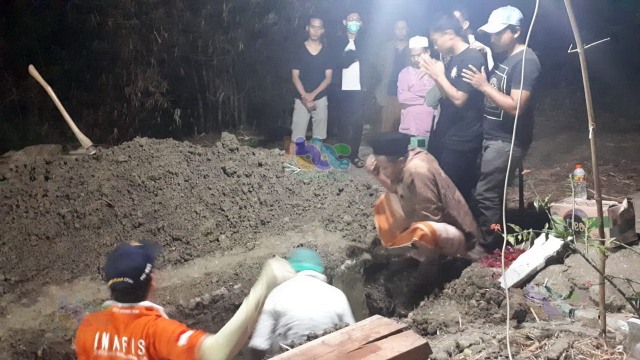 Anggota Polres Bojonegoro bersama Tim Medis dari RSUD Bojonegoro, saat lakukan pembongkaran makam dua warga Kedungadem. Selasa (17/09/2019) malam, untuk dilakukan otopsi.