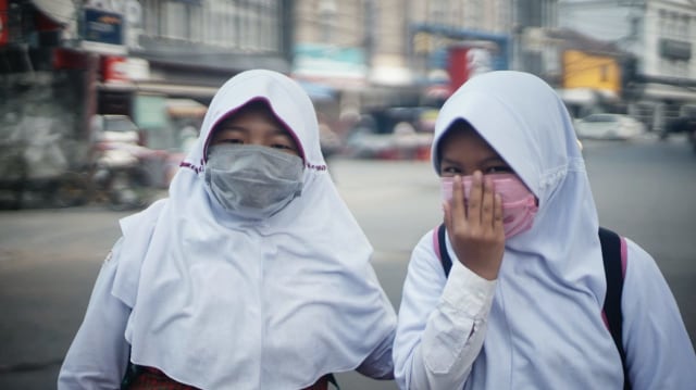 Sejumlah pelajar di Sumsel menggunakan masker untuk menghindari risiko terjangkit ISPA akibat kabut asap. (Foto: abp/Urban Id)