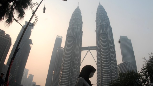 Warga beraktivitas dengan mengenakan masker di dekat menara kembar Petronas, Kuala Lumpur, Malaysia, Selasa (10/9/2019). Foto: ANTARA FOTO/Rafiuddin Abdul Rahman