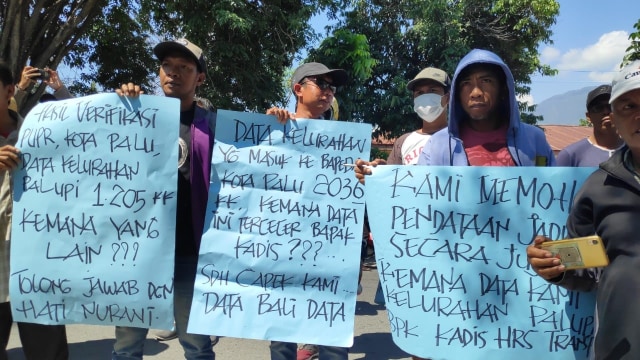 Massa aksi yang merupakan korban gempa Palu membentangkan poster dalam aksi menuntut bantuan Jadup dari Kementerian Sosial, Kamis (19/9), di depan Kantor Dinas Sosial Palu. Foto: Ikram/PaluPoso