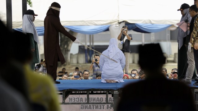 Seorang pelanggar syariat Islam menjalani hukuman cambuk di Taman Bustanussalatin, Banda Aceh, Kamis (19/9). Foto: Abdul Hadi/acehkini