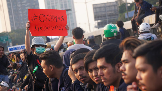 Mahasiswa yang membawa poster #ReformasiDikorupsi. Foto: Fanny Kusumawardhani/kumparan