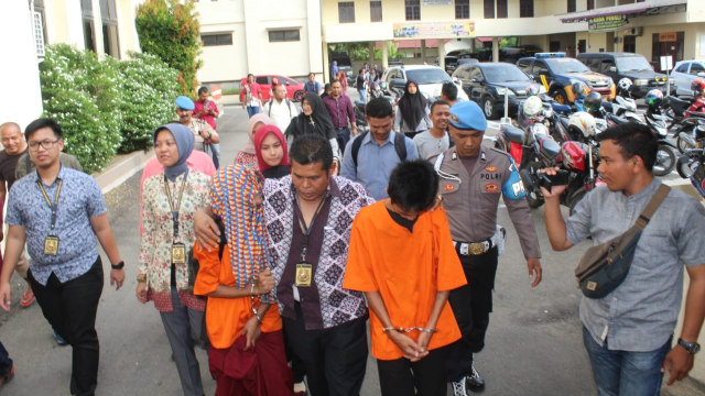 Anggota Polres Lhokseumawe membawa pelaku kekerasan terhadap anak kandung sendiri di Lhokseumawe, Aceh. Foto: Dok. Polres Lhokseumawe