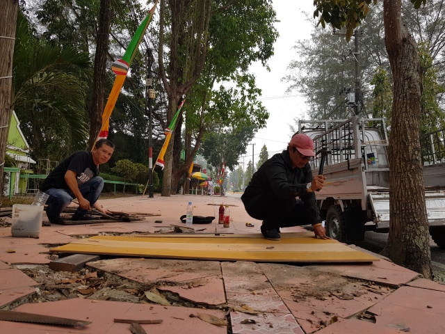Ketua Pengurus bersama Wakil Ketua IP CFD Pangkalan Bun memperbaiki trotoar yang berlubang di Jalan H.M Rafi'i Pangkalan Bun. (Foto: Joko Hardyono)