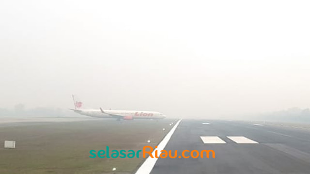 Pesawat Lion Air saat hendak masuk ke jalur runway atau tinggal landas di tengah asap putih tebal yang menyelimuti Bandara Sultan Syarif Kasim (SSK) II, Pekanbaru, Minggu (22/9). (Foto: FAKHRUR RODZI)