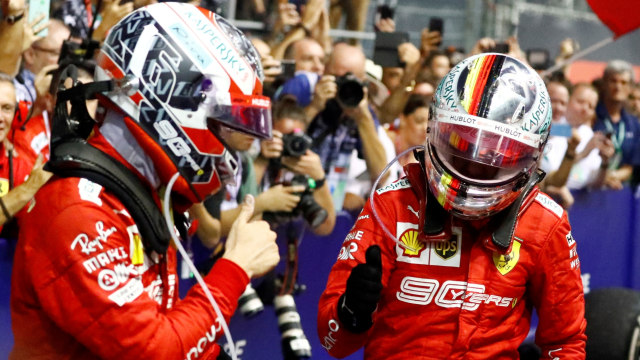 Sebastian Vettel dan Charles Leclerc usai membalap di F1 Singapura. Foto: REUTERS/Tim Chong