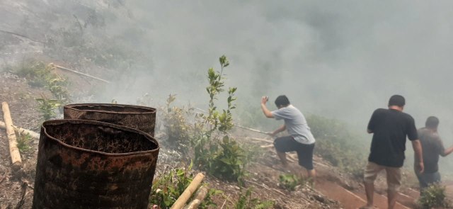 Warga Dusun Nahel berusaha memadamkan api yang membakar hutan serta lahan, Minggu (22/9) (Foto: istimewa)