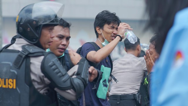 Seorang mahasiwa yang menyiramkan air ke wajah untuk menghilangkan efek gas air mata petugas, Selasa(24/9) Foto:abp/Urban Id