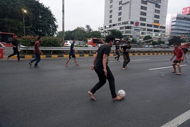 Sejumlah warga bermain bola di Tol Dalam Kota, Jakarta, pada Rabu (25/9/2019). Foto: Iqbal Firdaus/kumparan