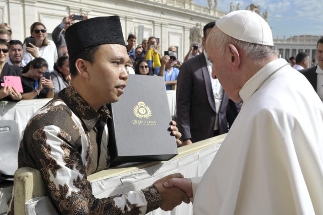 Ketua Pengurus Wilayah Gerakan Pemuda (PW-GP) Ansor Jawa Tengah Sholahuddin Aly menghadiahi Paus Fransiskus sebuah batik dalam kesempatan pertemuan di Vatikan, Rabu (25/9). Foto: Dok. Vatikan