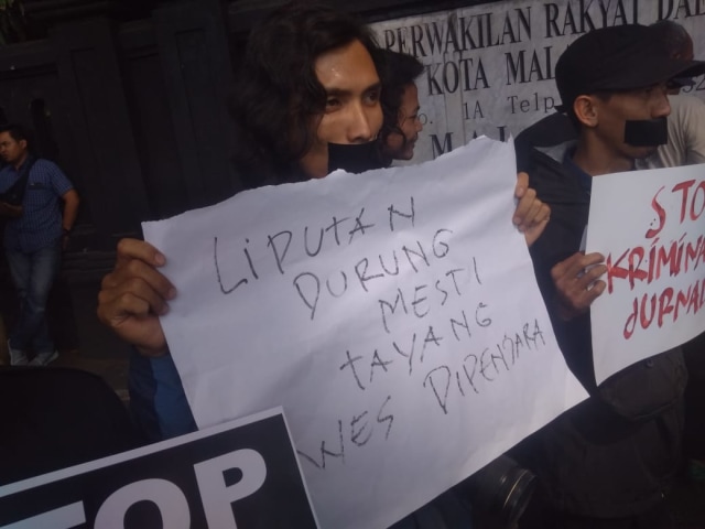 Sejumlah jurnalis melakban mulut mereka di depan DPRD Kota Malang, jum'at (27/9). foto: rezza do'a lathanza/tugumalangid