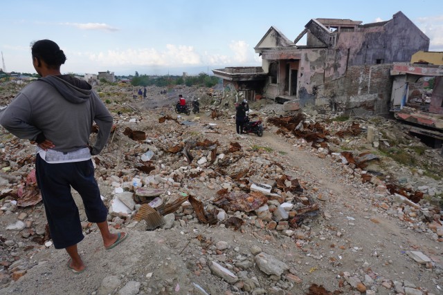 Warga berada di sekitar puing pemukiman mereka yang hancur akibat bencana gempa dan likuefaksi di Perumnas Balaroa, Palu, Sulawesi Tengah, Jumat (27/9/2019). Foto: ANTARA FOTO/Mohamad Hamzah