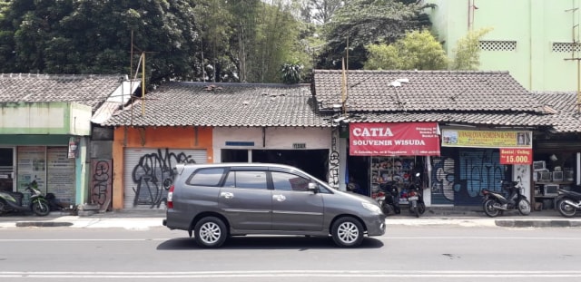 Sebuah mobil melintas di depan kios di Jalan Gejayan yang tutup akhibat aksi Gejayan Memanggil Jilid 2, Senin (30/9/2019). Foto: Dion.