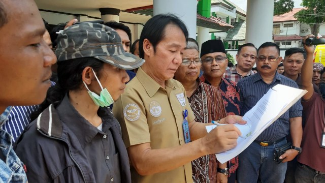 Kepala Kantor Wilayah Kemenkumham Sulawesi Tenggara, Sofyan, menandatangi surat dari mahasiswa yang meminta dibentuk tim independen dalam menyelidiki kasus kematian Randy dan Yusuf, Foto: Wiwid Abid Abadi/kendarinesia.